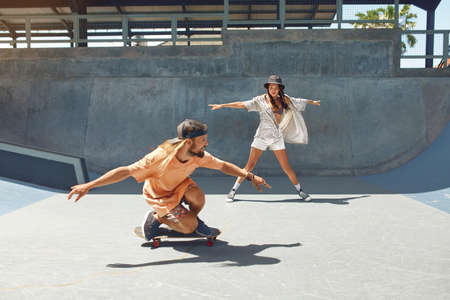 Skateboarding. Friends In Casual Outfit With Skateboards Riding On Concrete Ramp At Skatepark. Skater Subculture And Summer Activity As Lifestyle. Extreme Sport For Active Urban Guys And Girls.の写真素材