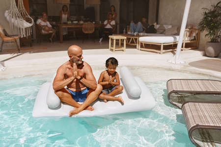 Pool. Father With Son Meditating And Floating On Inflatable Water Mattress. Dad And Kid Enjoying Vacation At Tropical Resort. Family Weekend In Villa. Happiness As Lifestyle.の写真素材