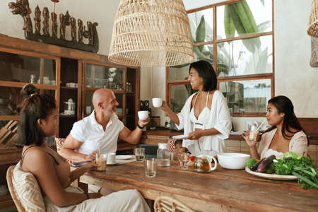 Kitchen. Family Lunch At Tropical Hone On Weekend. Interracial Parents With Mixed Race Daughters Drinking Tea And Cocktails. Organic Fruit And Vegetables With Natural Vitamins For Healthy Diet.の写真素材