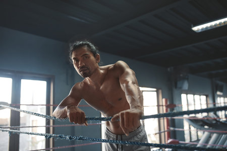 Portrait Of Man On Boxing Ring. Sexy Asian Sportsman With Strong, Healthy, Muscular Body At Fitness Center. Boxer With Elastic Tapes On Wrists Having Break After Training At Gym.の写真素材