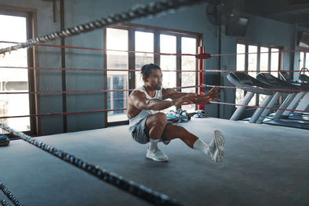 Portrait Of Man On Boxing Ring. Sexy Asian Sportsman With Strong, Healthy, Muscular Body At Fitness Center. Boxer With Elastic Tapes On Wrists Having Break After Training At Gym.の写真素材