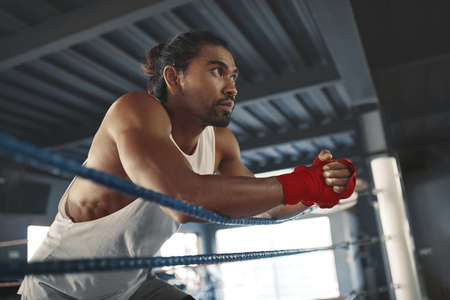 Portrait Of Man On Boxing Ring. Sexy Asian Sportsman With Strong, Healthy, Muscular Body At Fitness Center. Boxer With Elastic Tapes On Wrists Having Break After Training At Gym.の写真素材
