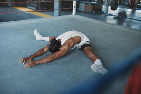 Gym. Man Stretching On Boxing Ring Before Intense Workout. Sexy Asian Sportsman Warming Up At Fitness Center. Bodybuilding For Strong, Muscular And Healthy Body. Sport Training As Lifestyle.の写真素材