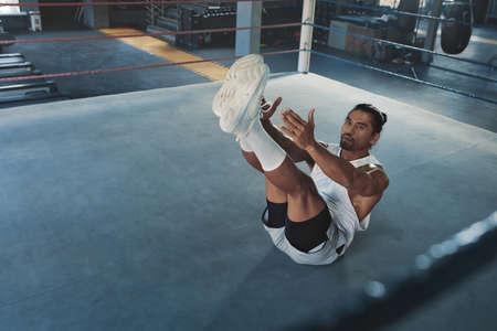Gym. Man Doing Abs Workout On Boxing Ring. Asian Sportsman Exercising On Floor At Sports Center. Portrait Of Sexy Handsome Guy With Strong, Healthy, Muscular Body Warming Up Indoor.の写真素材