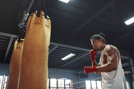 Gym. Man Near Punching Bag. Asian Sportsman Going To Knock Boxing Equipment At Fitness Center. Portrait Of Sexy Handsome Guy With Strong, Healthy, Muscular Body.の写真素材