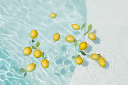 Pool Water With Lemons. Pure Aqua Surface With Glares Pattern And Floating Fresh Citrus.の写真素材
