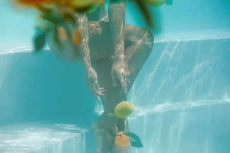 Body Underwater. Beautiful Woman Posing In Pool With Citrus. Sexy Slim Model In Bikini At SPA.の写真素材