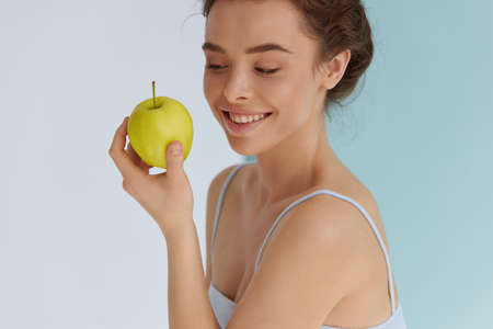 Woman with green apple. Female model looking at green appleの写真素材