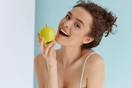 Woman with green apple. Woman with smile holding green appleの写真素材