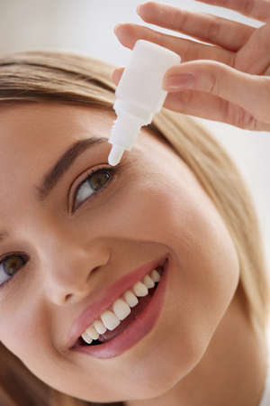 Woman With Eye Drops. Closeup Of Girl Applying Eye Drops In Eyesの写真素材