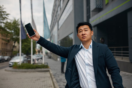 Male Businessman Catch Free Taxi at Busy Time. Asian Man Stop the Carの写真素材