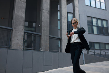 Busy Business Woman Checking Time while Hurry Up at Work. Lady Holding Coffeeの写真素材