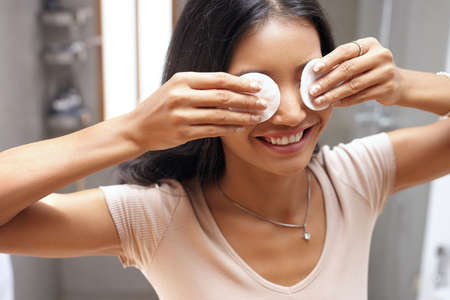 Face Skin Care. Girl Removing Makeup with Cosmetic Cotton Pad at Bathroomの写真素材