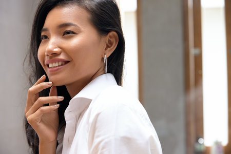 Portrait Of Attractive Female Touching Smooth Facial Skin With Handの写真素材