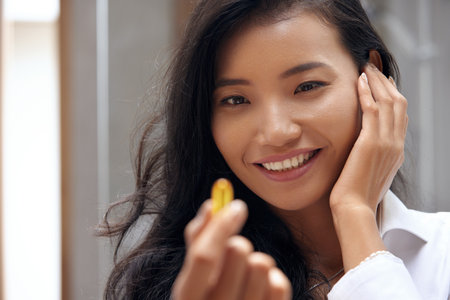 Happy Smiling Woman Taking Pill With Cod Liver Oil Omega-3 In Morningの写真素材