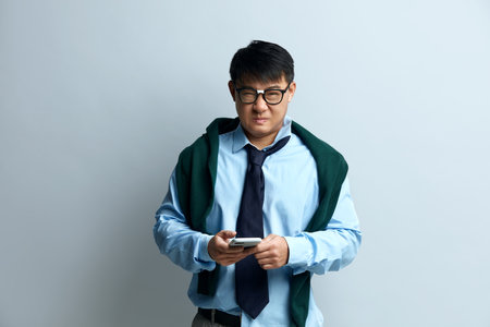 Sad Man Holding Smartphone. Young Businessman Holding Cellphone with Sad Faceの写真素材