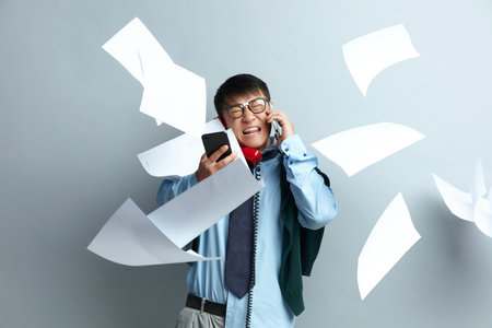 Busy Man Working Isolated. Asian Businessman With Pile of Papers Flying on Airの写真素材
