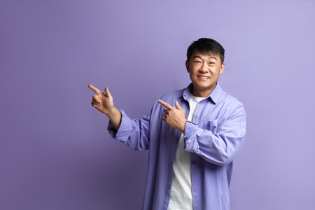 Smiling Man Pointing Hand. Positive Guy Pointing Away Paying Your Attentionの写真素材