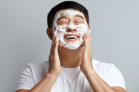 Man Face Skin Care. Asian Happy Guy Cleansing Face with Foam Soapの写真素材
