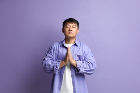 Peaceful Man Meditating at Studio. Portrait of Asian Guy Doing Prayer Gestureの写真素材