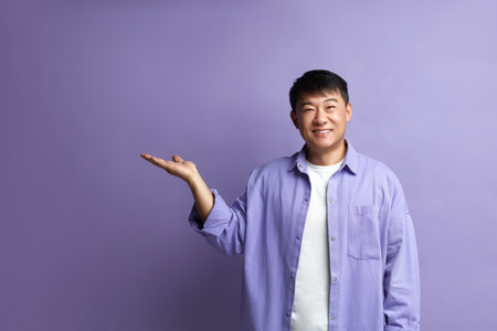 Smiling Man Pointing Hand. Positive Guy Pointing Away Paying Your Attentionの写真素材