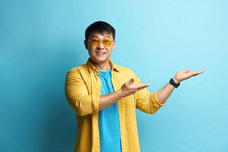 Smiling Man Pointing Hand. Positive Guy Pointing Away Paying Your Attentionの写真素材
