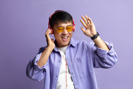 Asian Man Listening Music. Positive Man Listening Song Wearing Headphonesの写真素材