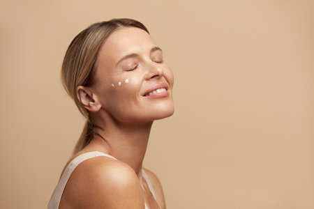 Woman Cream Drops On Face. Portrait Of Woman Closed Eyes With Cream On Skinの写真素材