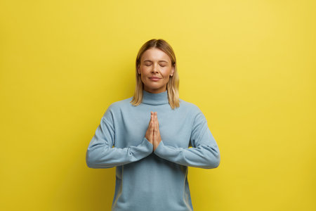 Peaceful Woman Meditating at Studio. Portrait of Young Girl Doing Prayer Gestureの写真素材