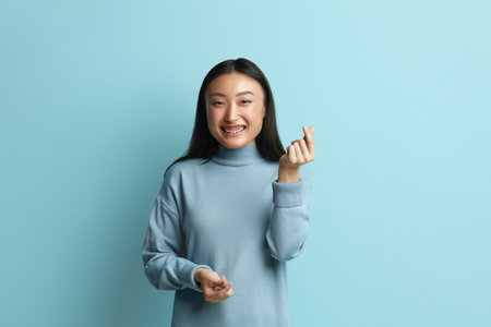 Positive Woman Showing Money Gesture. Portrait of Asian Girl Asking for Paymentの写真素材