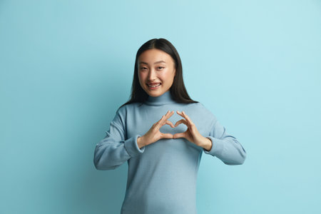 Asian Woman Showing Love Gesture. Romantic Woman Making Heart with Handsの写真素材