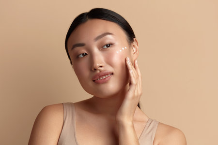 Skin Care Woman Applying Cream on Cheek. Asian Girl Putting Cream On Skinの写真素材