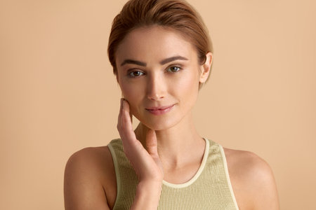 Smiling Woman Touching Face. Waist Up Portrait of Woman Touching Her Skinの写真素材