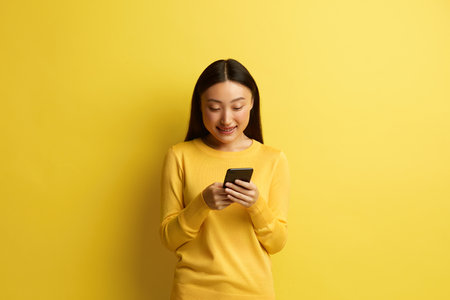 Happy Woman Holding Smartphone Isolated. Asian Girl Messaging Cellphoneの写真素材