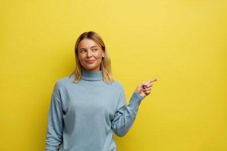 Cute Woman Pointing Aside. Amused Girl Points Fingers Away at Empty Copy Spaceの写真素材