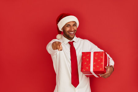 Smiling Man Pointing at You. Positive Guy Pointing Finger and Holding Presentの写真素材