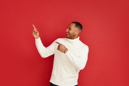Smiling Man Pointing Hand. Positive Multiracial Guy Pointing Awayの写真素材