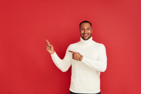 Smiling Man Pointing Hand. Positive Multiracial Guy Pointing Awayの写真素材