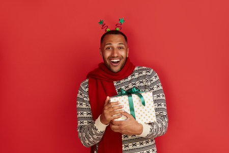 Surprised Man Holding Present. Excited Multiracial Guy Holding Present Boxの写真素材