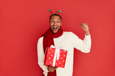 Surprised Man Holding Present. Excited Multiracial Guy Holding Present Boxの写真素材