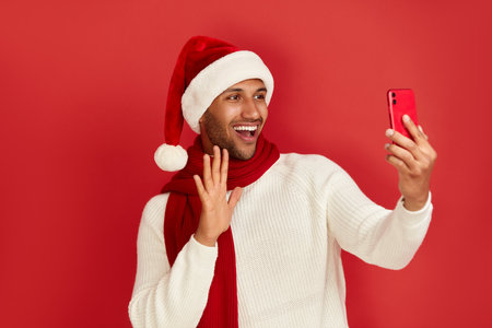 Happy Man Using Smartphone. Multiracial Guy Smiling Using Videocalling Cellphoneの写真素材