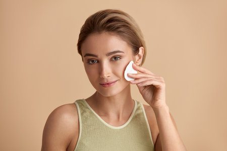 Woman Cleaning Face With White Pad. Beautiful Girl Removing Makeupの写真素材