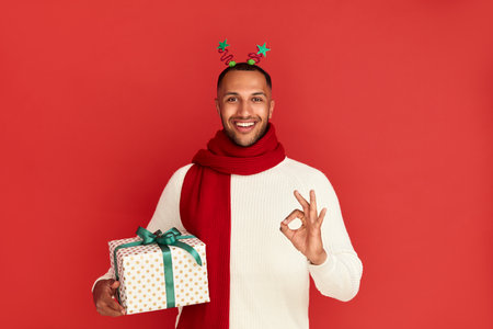 Smiling Man Showing Ok Gesture. Multiracial Guy Satisfied with Presentの写真素材