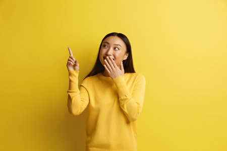 Happy Woman Pointing Up. Amused Asian Girl Points Fingers Awayの写真素材