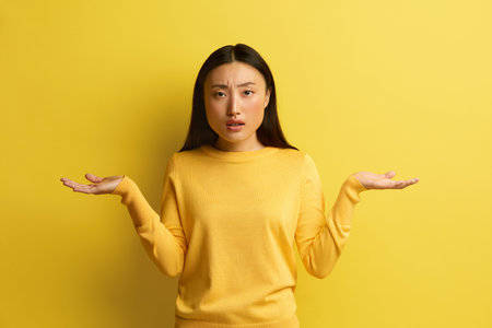 Confused Woman Shrugging Hands. Portrait Uncertain Asian Girl Expressing Doubtsの写真素材