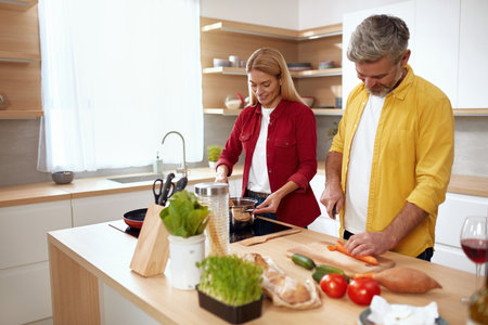 Couple Cooking At Kitchen. Senior Positive Man Cutting Vegetables For Saladの写真素材