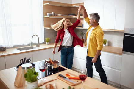 Romantic Couple Dancing Kitchen. Playful Mature Spouses Dancing And Smilingの写真素材