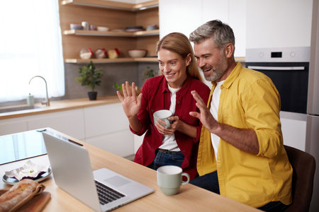 Smiling Couple Videocalling Laptop. Friendly Senior Spouses Talking With Familyの写真素材