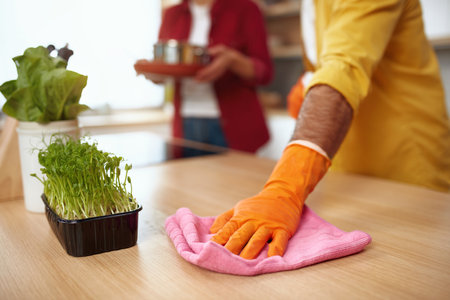 Closeup Man Cleaning Table. Caring Senior Guy Wiping Kitchen Tableの写真素材