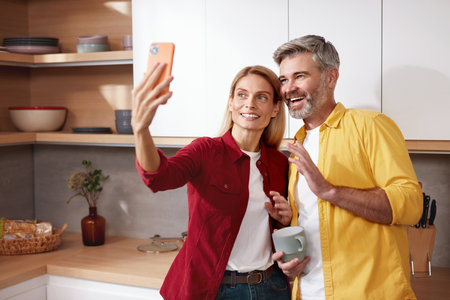 Smiling Couple Videocalling Smartphone. Friendly Senior Spouses Talking Familyの写真素材
